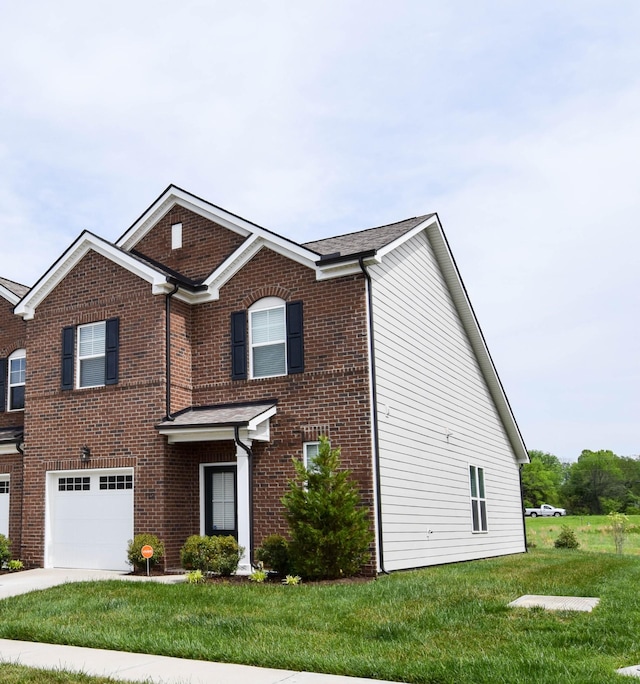 traditional-style house featuring brick siding, an attached garage, a front lawn, and concrete driveway