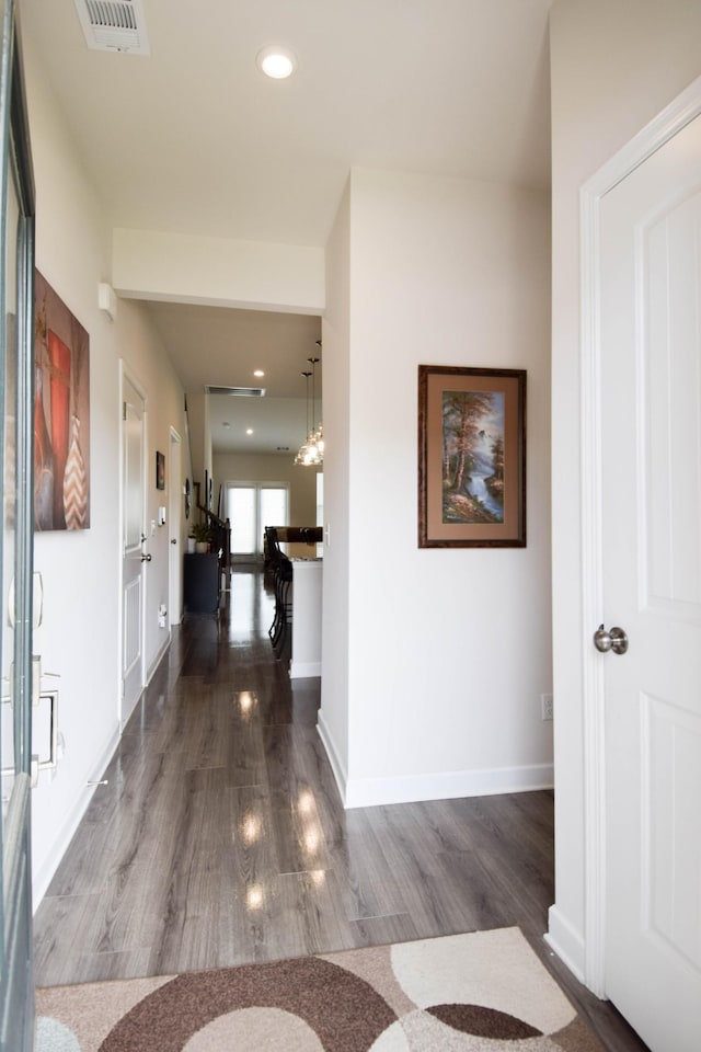 hallway featuring baseboards, dark wood-type flooring, visible vents, and recessed lighting