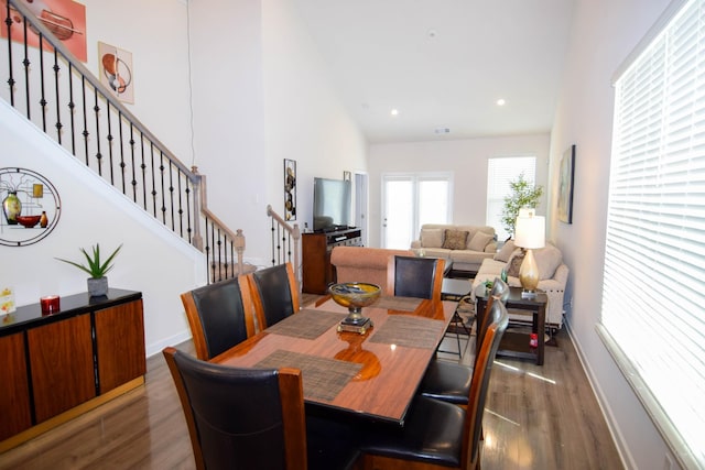 dining room featuring recessed lighting, stairway, high vaulted ceiling, and wood finished floors