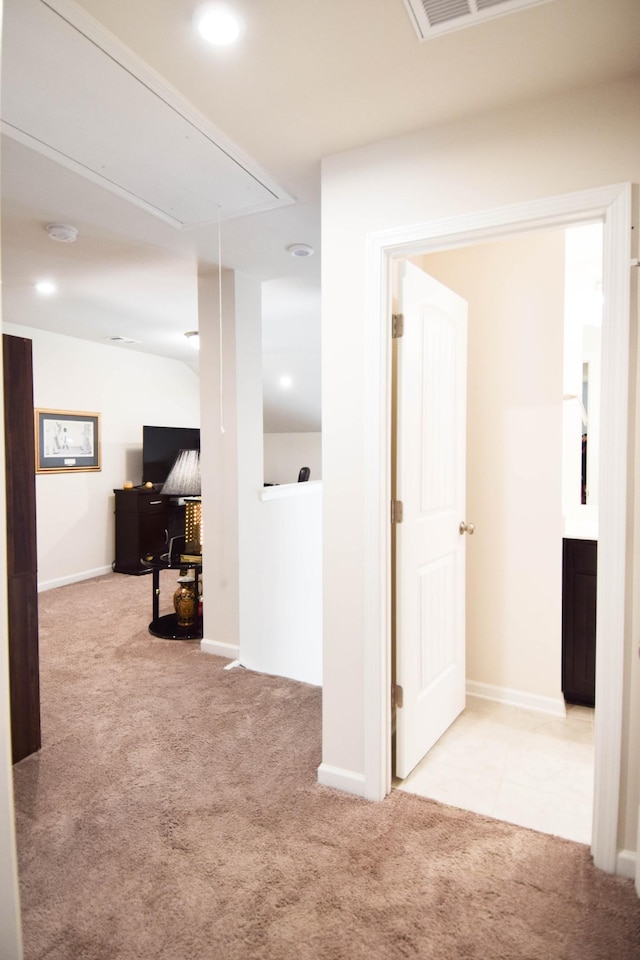 hallway featuring attic access, carpet floors, visible vents, and baseboards
