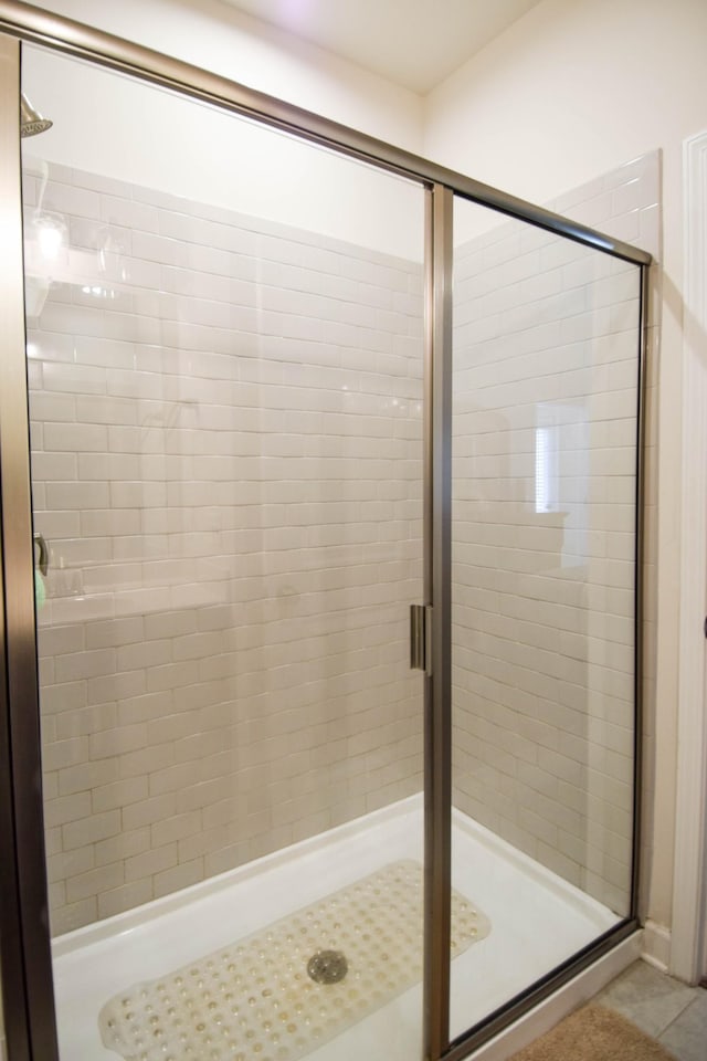 bathroom featuring tile patterned flooring and a shower stall