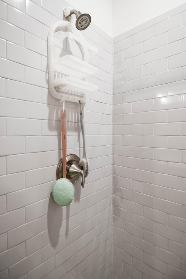 interior details featuring a tile shower