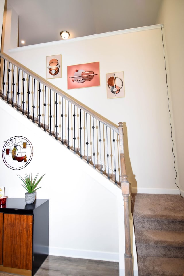 stairway with wood finished floors and baseboards