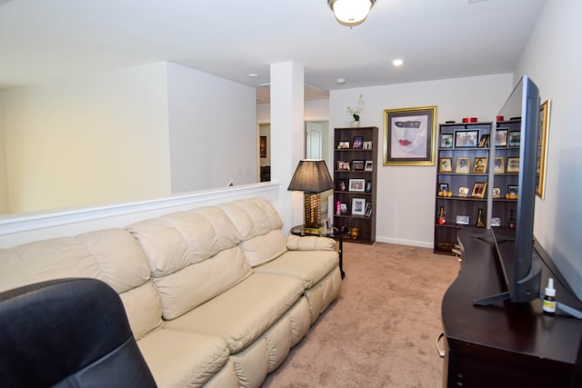 living area featuring baseboards and light colored carpet
