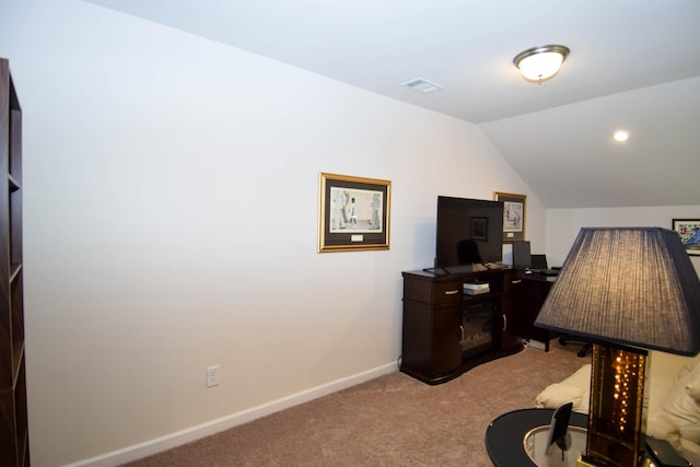 office space featuring lofted ceiling, baseboards, and light colored carpet
