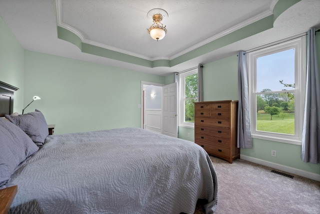 carpeted bedroom with baseboards, crown molding, and visible vents