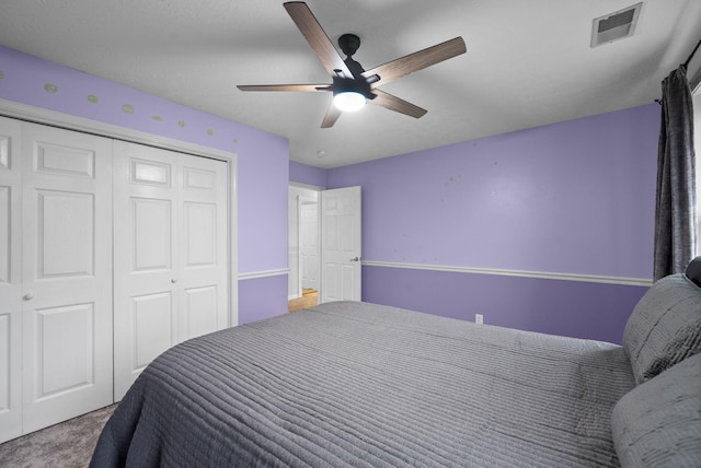 carpeted bedroom with ceiling fan, visible vents, and a closet