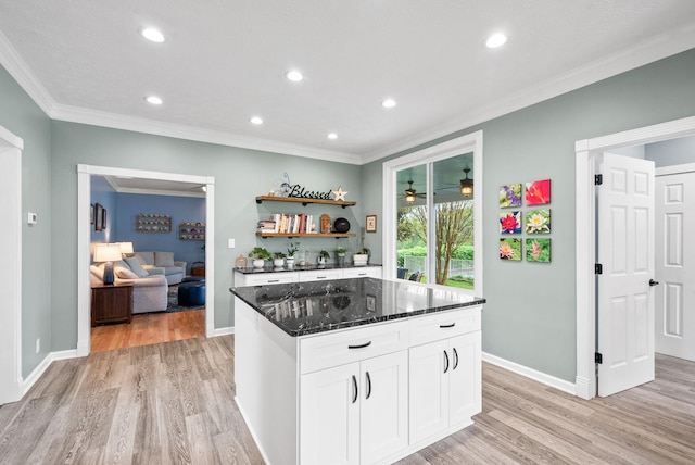 kitchen featuring dark stone countertops, light wood-type flooring, white cabinetry, open shelves, and ornamental molding