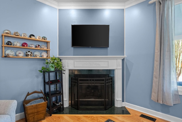 details featuring wood finished floors, visible vents, a tile fireplace, and ornamental molding