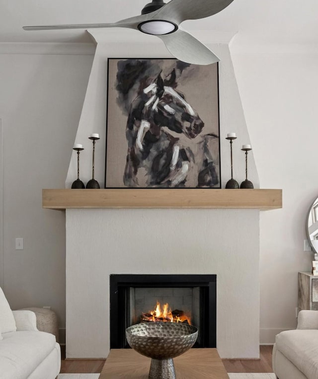 room details featuring crown molding, wood finished floors, and a lit fireplace