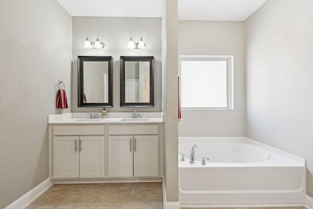 full bath with double vanity, a bath, baseboards, and a sink