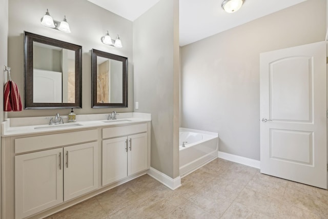 bathroom with a bath, baseboards, a sink, and double vanity