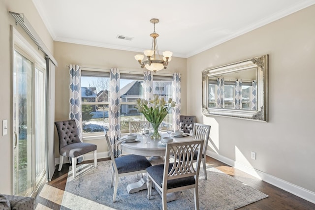 dining area featuring crown molding, baseboards, and an inviting chandelier