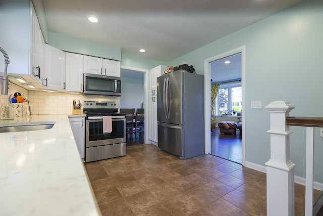 3201 Healy Dr, Nashville, TN 37207 - kitchen with tasteful backsplash, stainless steel appliances, light countertops, white cabinets, and recessed lighting