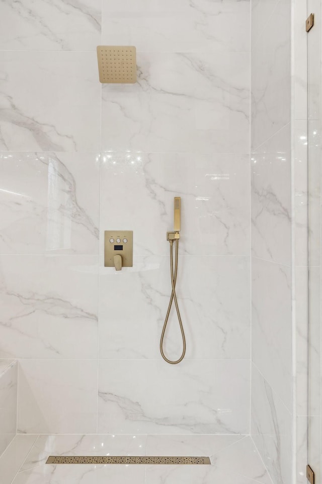 bathroom featuring a marble finish shower