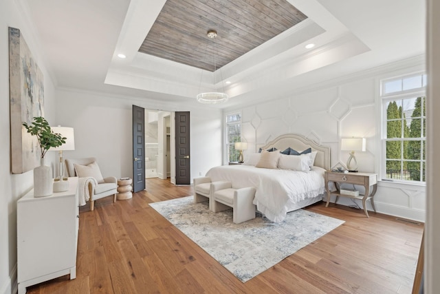 bedroom featuring crown molding, light wood-type flooring, a tray ceiling, baseboards, and recessed lighting