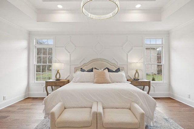 bedroom featuring a raised ceiling and multiple windows
