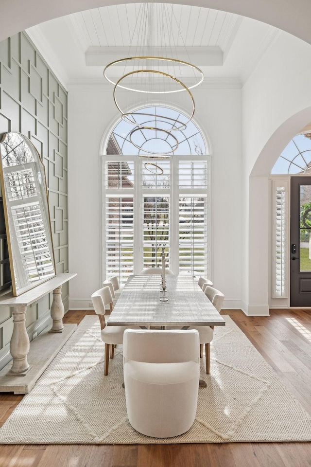 dining space with a tray ceiling, ornamental molding, and a healthy amount of sunlight
