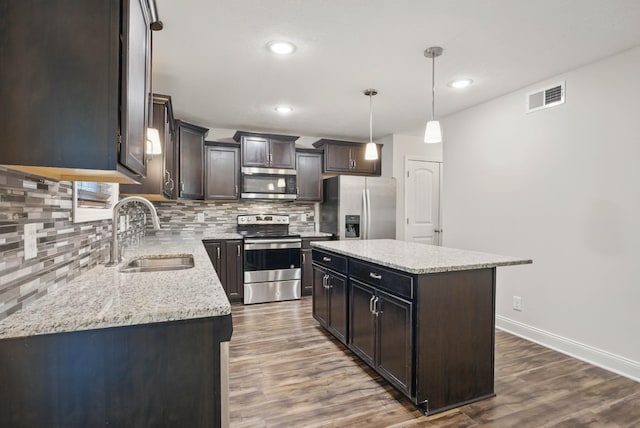 1200 Eagles Bluff Dr, Clarksville, TN 37040 - kitchen with appliances with stainless steel finishes, a sink, decorative backsplash, dark wood-type flooring, and baseboards