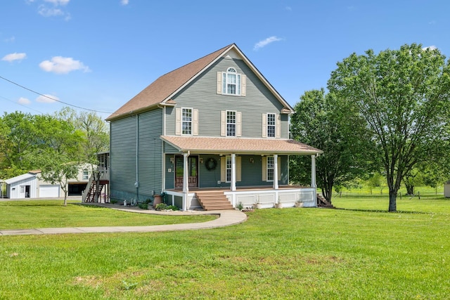 view of front of property featuring an outdoor structure, a front yard, and covered porch