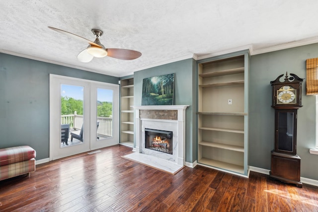 living room with wood finished floors, a ceiling fan, and ornamental molding