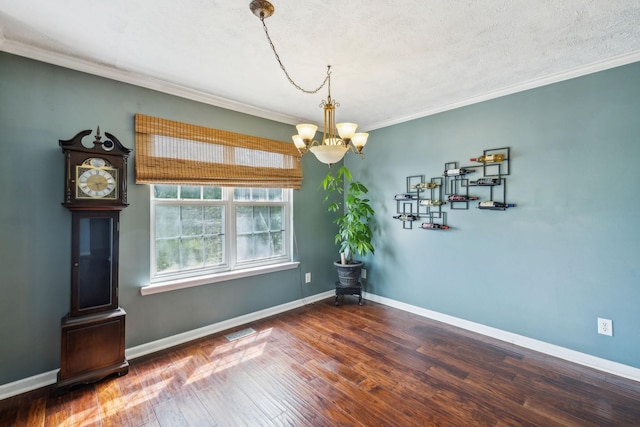 dining area with wood finished floors, an inviting chandelier, baseboards, ornamental molding, and visible vents