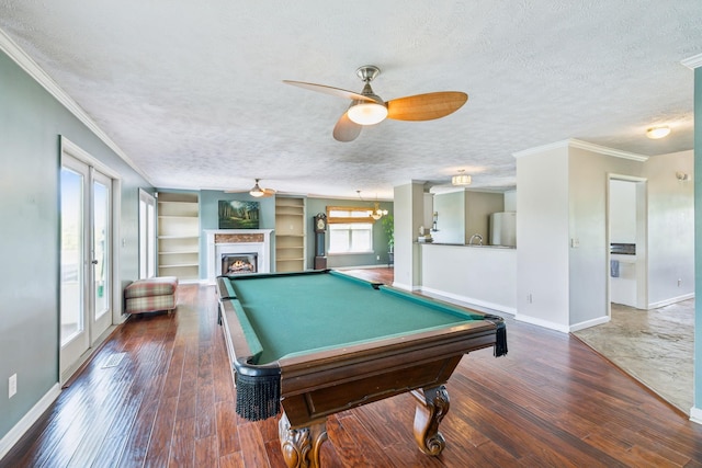 game room featuring baseboards, a textured ceiling, and ornamental molding