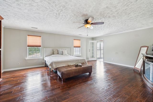 bedroom with hardwood / wood-style flooring, baseboards, crown molding, and visible vents