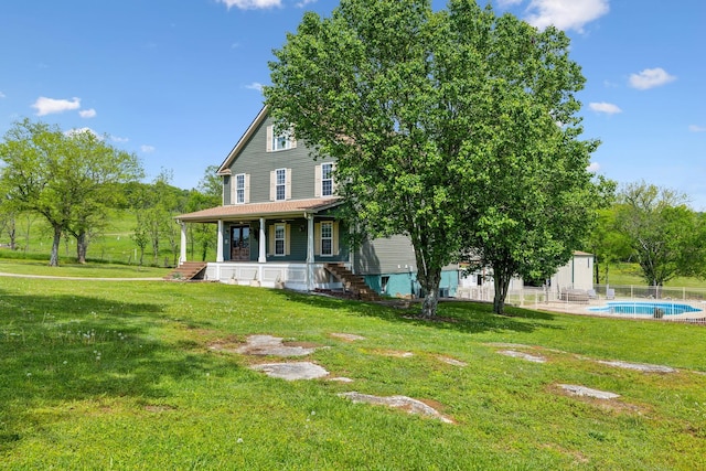 view of front of house with a porch, a fenced in pool, a front yard, and a shed