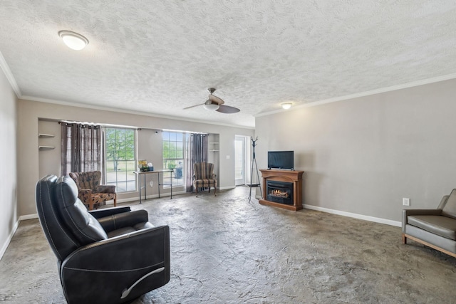 living room with a ceiling fan, a textured ceiling, a warm lit fireplace, baseboards, and ornamental molding