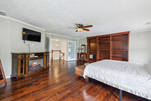 bedroom featuring visible vents, wood finished floors, a textured ceiling, and crown molding