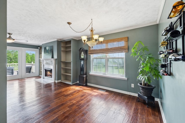 unfurnished living room with hardwood / wood-style flooring, baseboards, a textured ceiling, and a healthy amount of sunlight