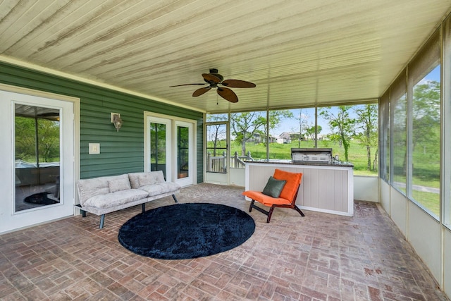 sunroom / solarium with a ceiling fan and a wealth of natural light