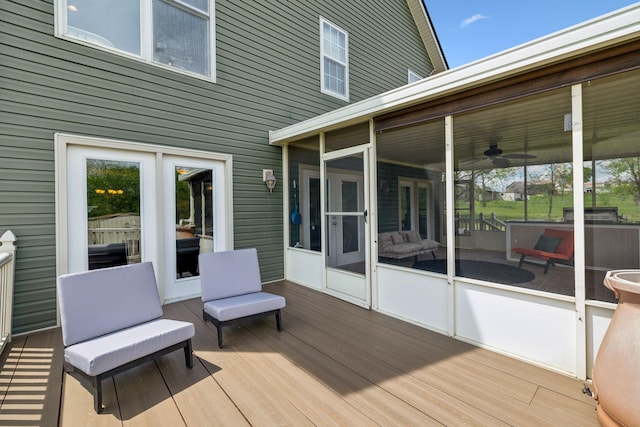 wooden deck with a sunroom and a ceiling fan