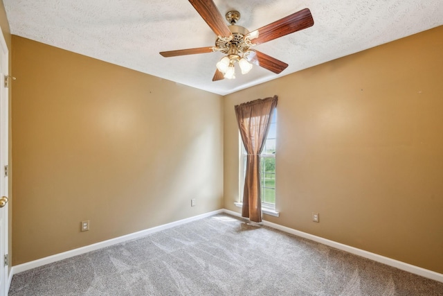 empty room with a ceiling fan, baseboards, carpet floors, and a textured ceiling