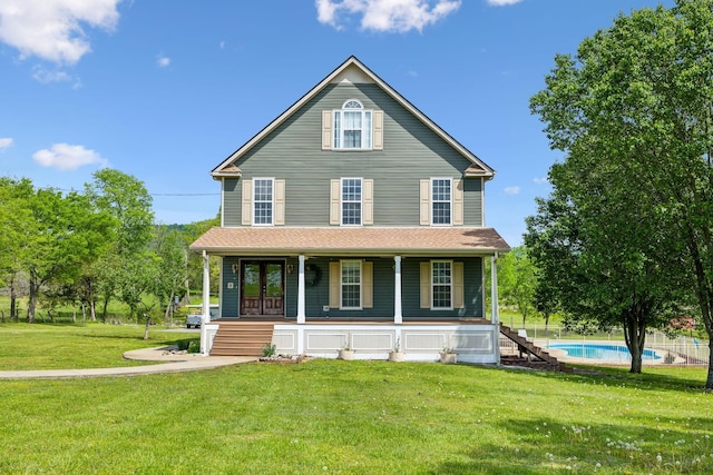 farmhouse featuring a porch, an outdoor pool, and a front yard