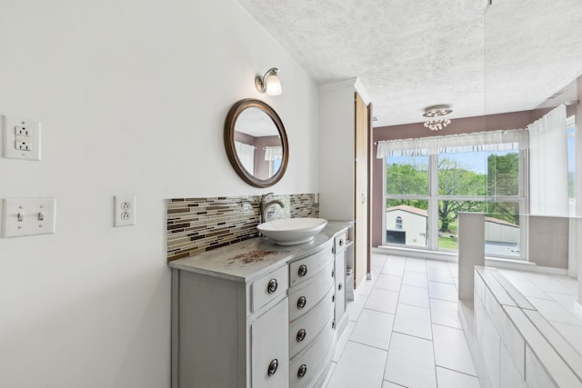 bathroom featuring backsplash, tile patterned floors, vanity, and a textured ceiling