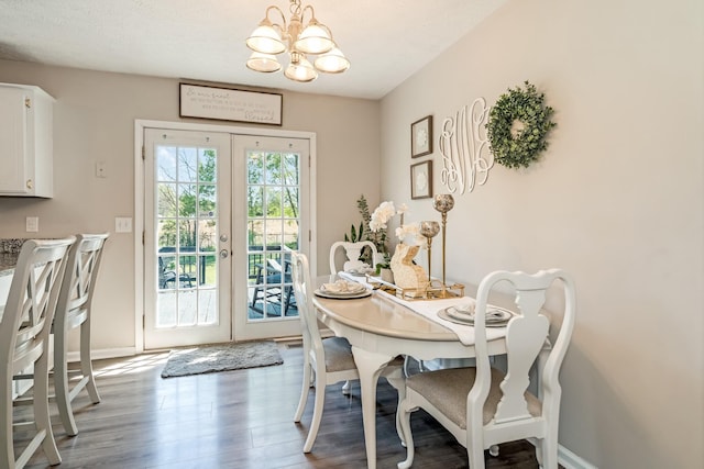 dining room featuring wood finished floors, baseboards, french doors, and an inviting chandelier