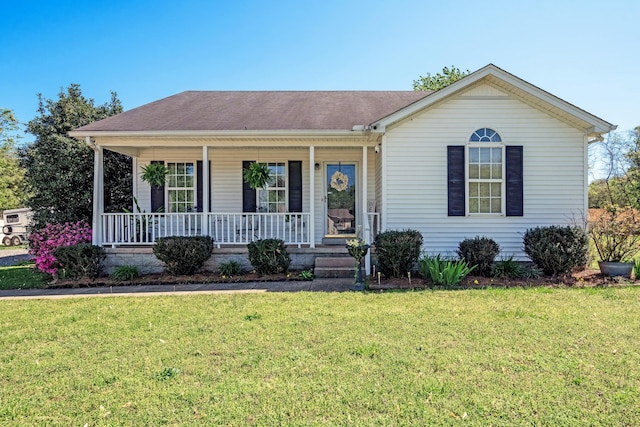 ranch-style house featuring a porch, a shingled roof, and a front yard