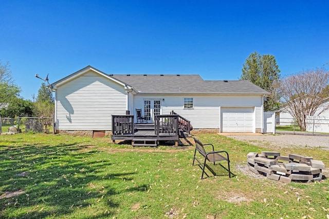 back of house with fence, a wooden deck, and a lawn
