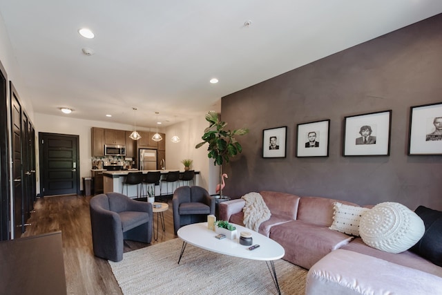 living room with recessed lighting and dark wood-style floors