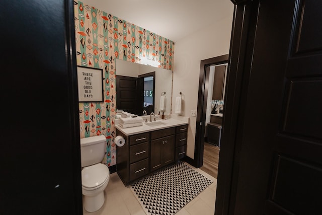 bathroom featuring wallpapered walls, toilet, vanity, and tile patterned floors