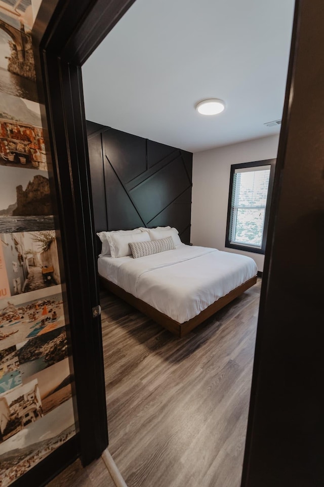 bedroom with wood finished floors and visible vents