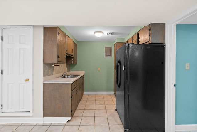 13391 Fruit Hill Red Bridge Rd, Crofton, KY 42217 - kitchen featuring a sink, light tile patterned flooring, black fridge, baseboards, and light countertops