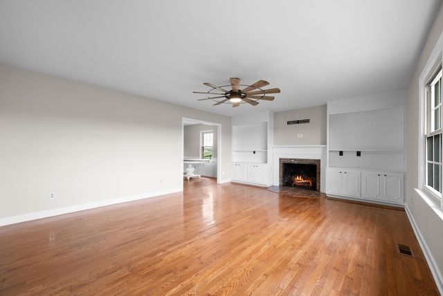 13391 Fruit Hill Red Bridge Rd, Crofton, KY 42217 - unfurnished living room featuring visible vents, light wood-style floors, baseboards, a fireplace, and built in features