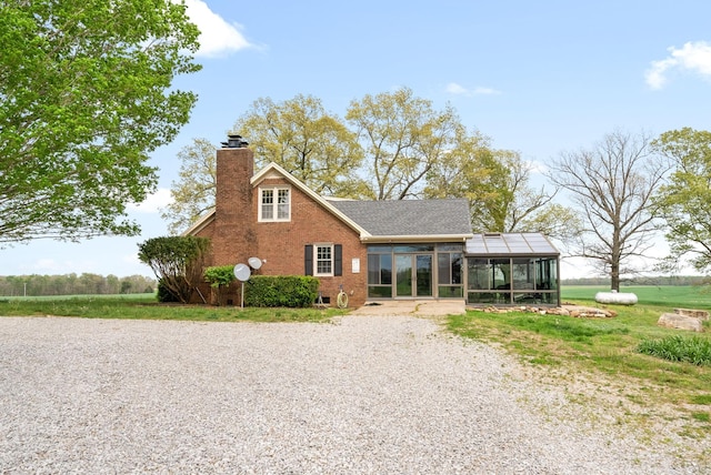 13391 Fruit Hill Red Bridge Rd, Crofton, KY 42217 - back of property with brick siding, a chimney, gravel driveway, a sunroom, and roof with shingles