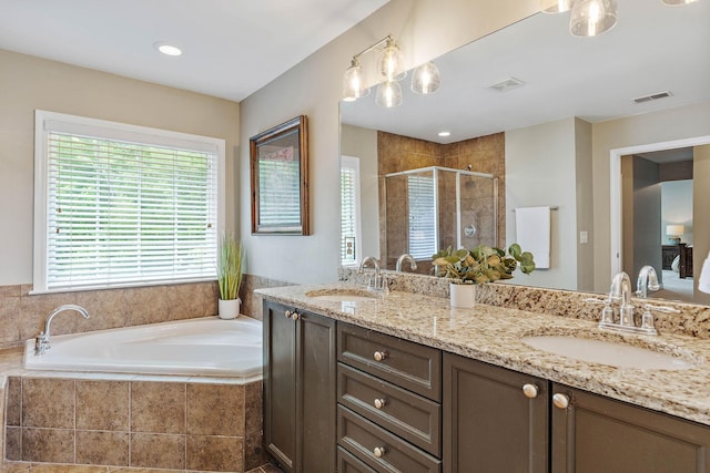 full bath with visible vents, a garden tub, a stall shower, and a sink