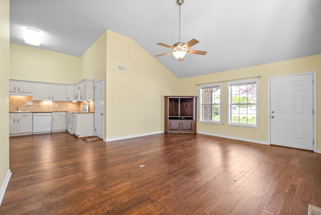 unfurnished living room with high vaulted ceiling, baseboards, a ceiling fan, and dark wood-style floors