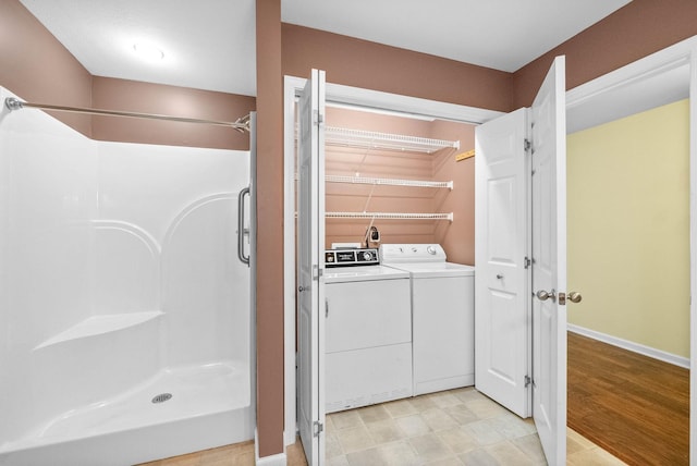 clothes washing area featuring independent washer and dryer and baseboards