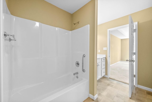 bathroom with baseboards, vanity, and shower / tub combination